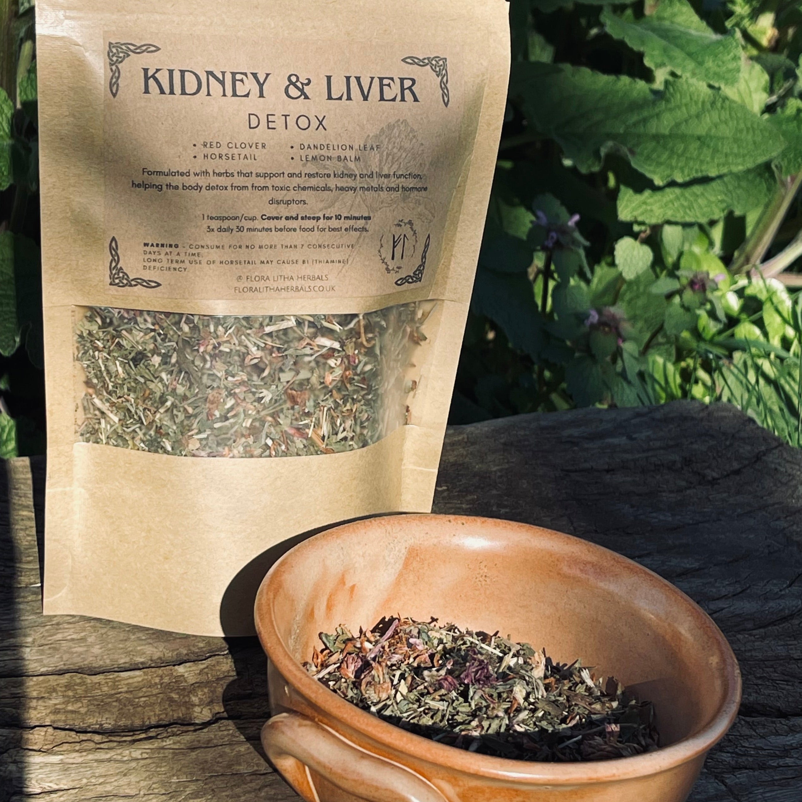 Herbal tea package labeled 'Kidney & Liver Detox' with a bowl of tea leaves on a natural background.