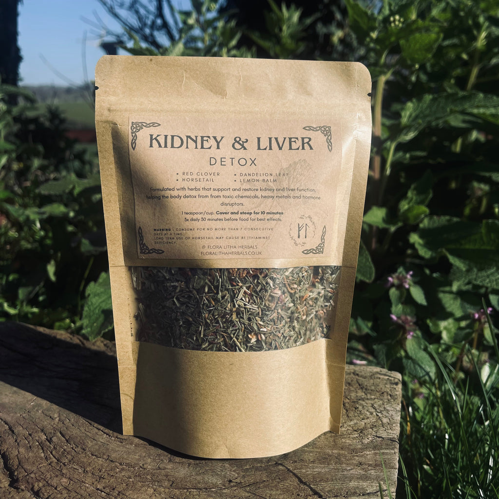 Kraft paper packaging of 'Kidney & Liver Detox' tea on a wooden surface with greenery in the background