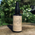Bottle of Flora Litha Strength of Heart herbal extract on a wooden surface with a natural background