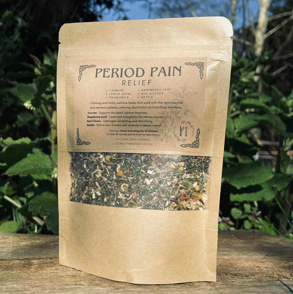 Kraft paper packaging of 'Period Pain Relief' herbal tea on a wooden surface with a natural background.